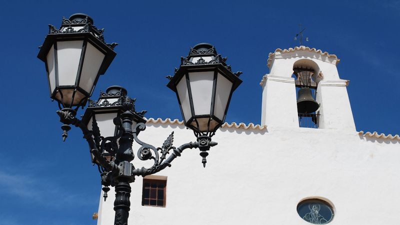 Detail of a street lamp and a church in a village on Ibiza